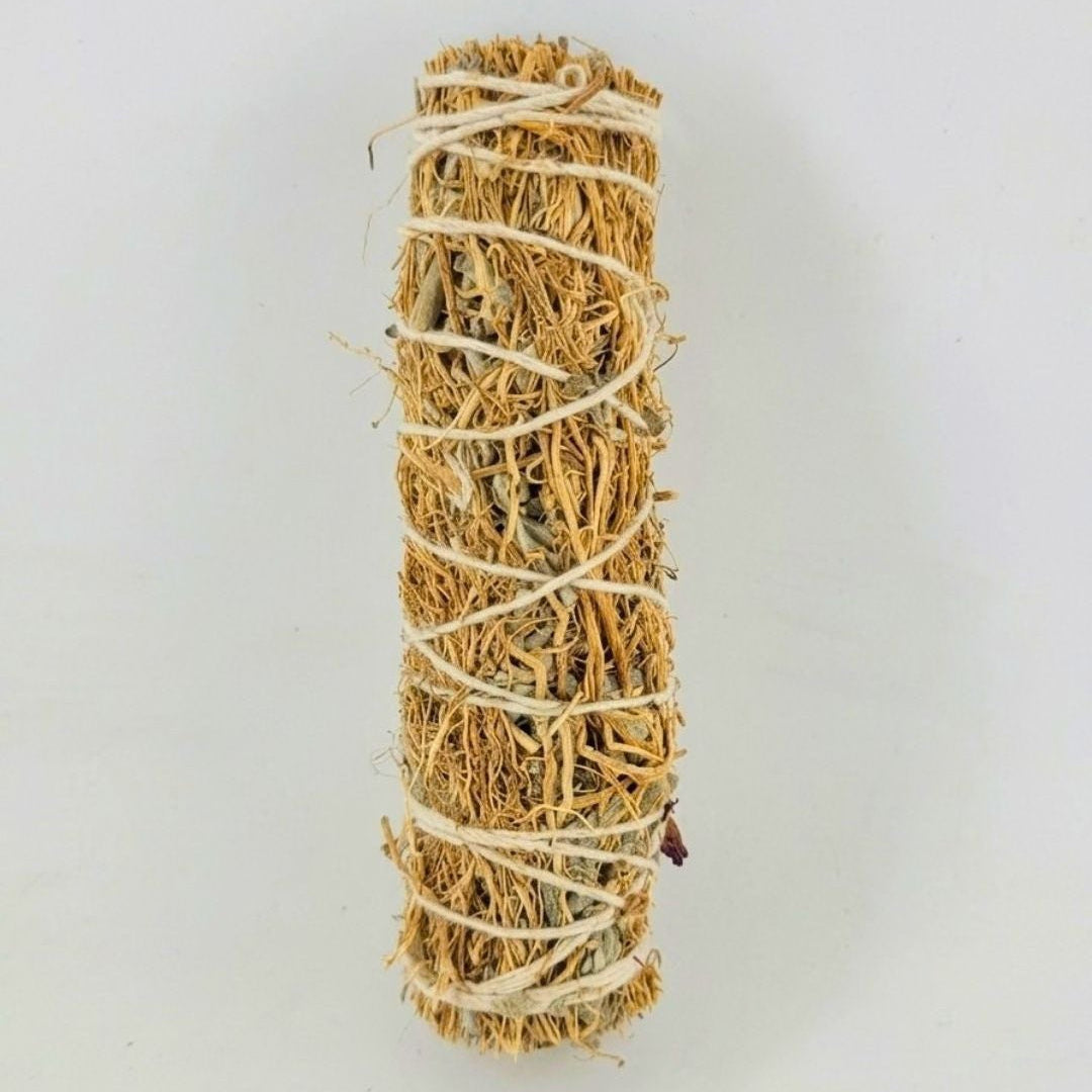 A natural dried vetiver smudge stick wrapped with white string, shown vertically against a plain light gray background.