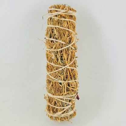 A natural dried vetiver smudge stick wrapped with white string, shown vertically against a plain light gray background.