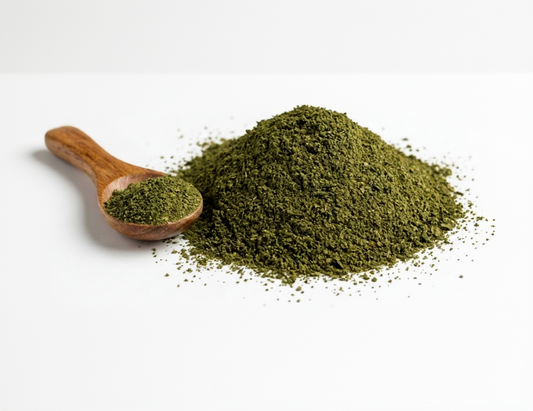 Wooden spoon with green powder and a pile of green powder on a white background